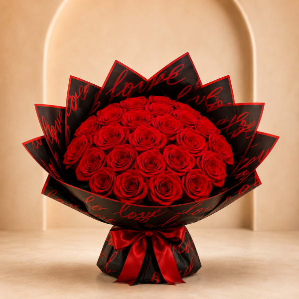 Bouquet of red roses wrapped in black paper with red script and a red ribbon