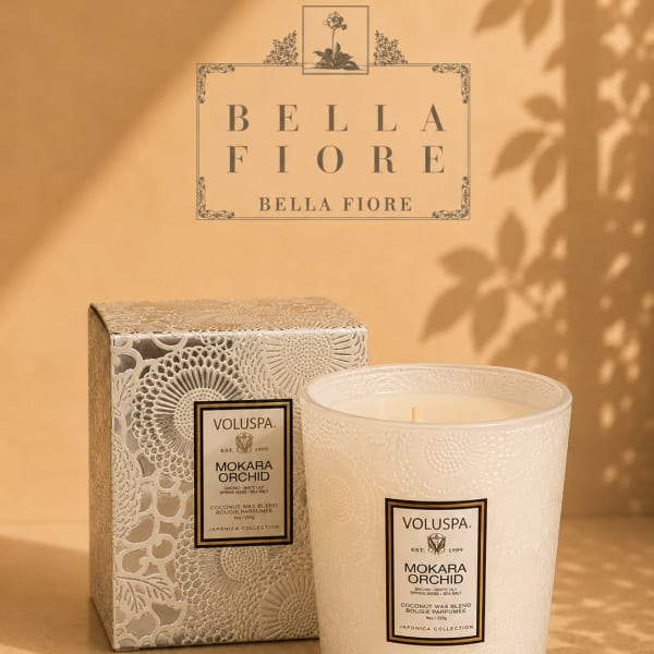 Decorative scented candle in a patterned glass jar with matching box