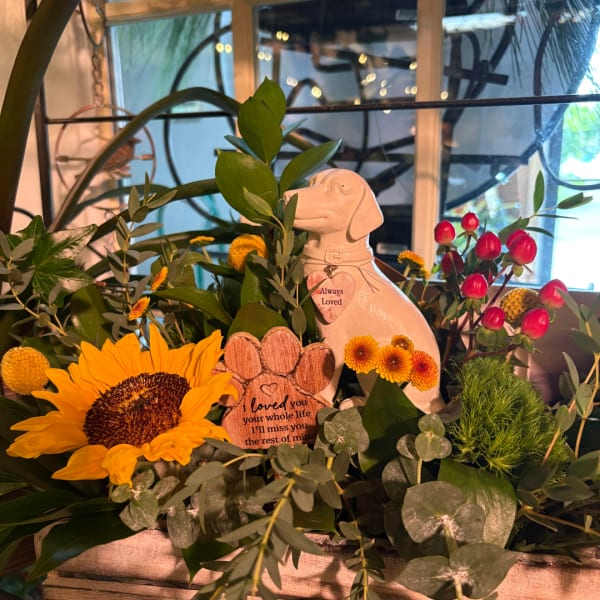 Sunflower arrangement with a dog figurine and memorial paw-print signs