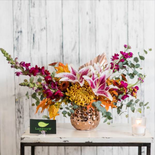 Bouquet of pink lilies and magenta flowers in a copper vase