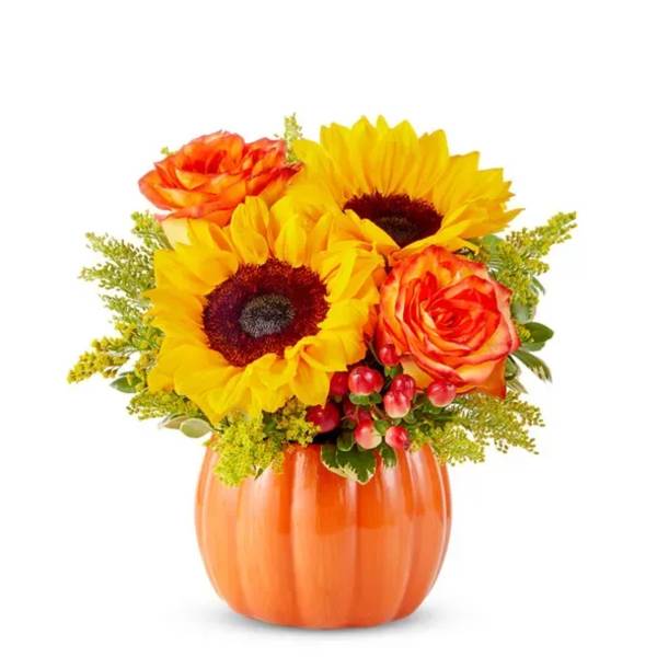 Sunflowers and orange roses in an orange pumpkin vase