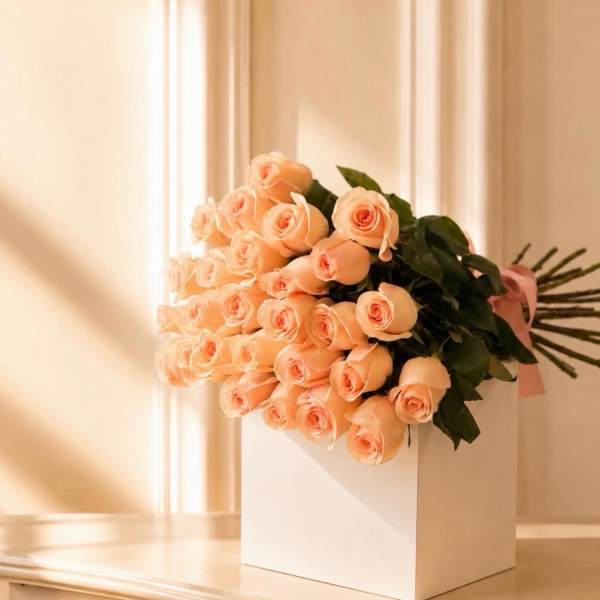 Bouquet of peach roses in a white box with a pink ribbon