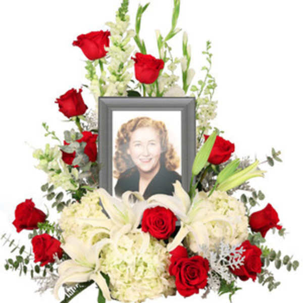 Memorial floral frame with red roses, white lilies, and a portrait