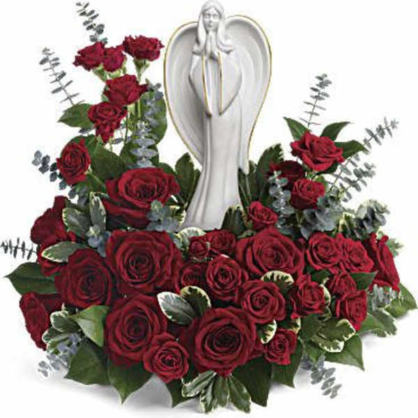 Sympathy arrangement of dark red roses surrounding a white angel figurine