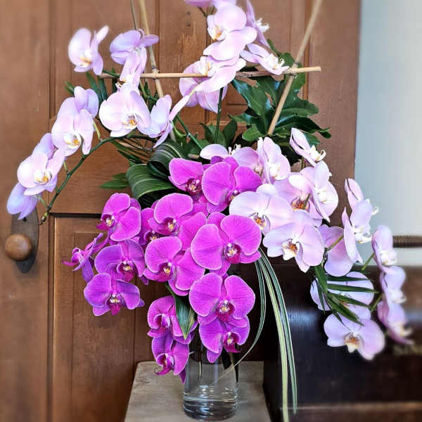 Arrangement of pink and purple orchids in a glass vase