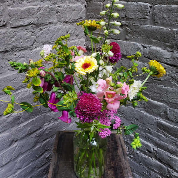 Mixed bouquet in a glass vase with pink, white, and yellow flowers