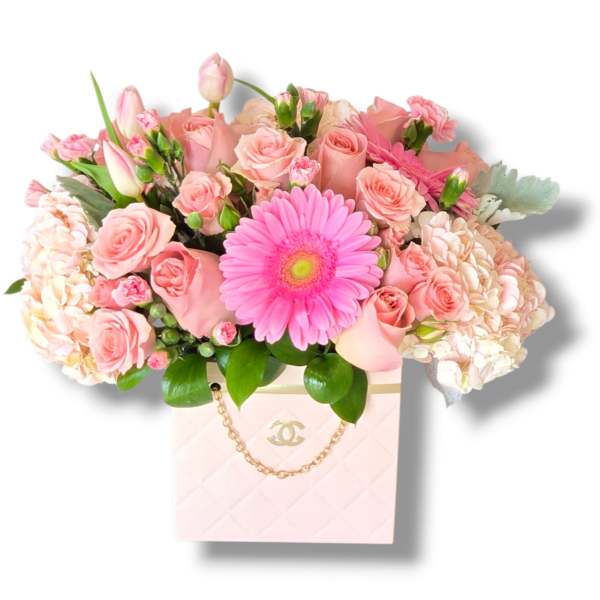 Pink roses and a gerbera daisy in a pale pink box bag