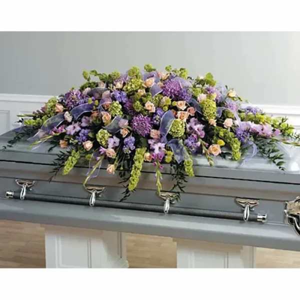 Lavender and peach floral spray on a gray casket