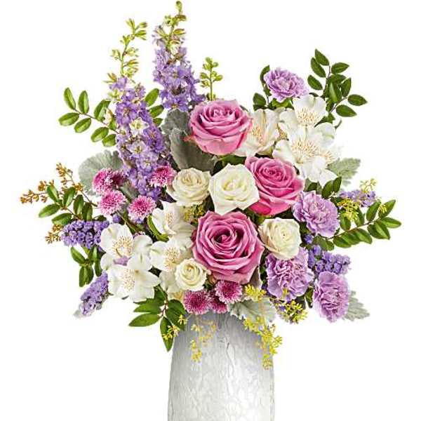 Pink and white roses with purple flowers in a white vase