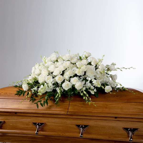 White rose arrangement on a wooden casket