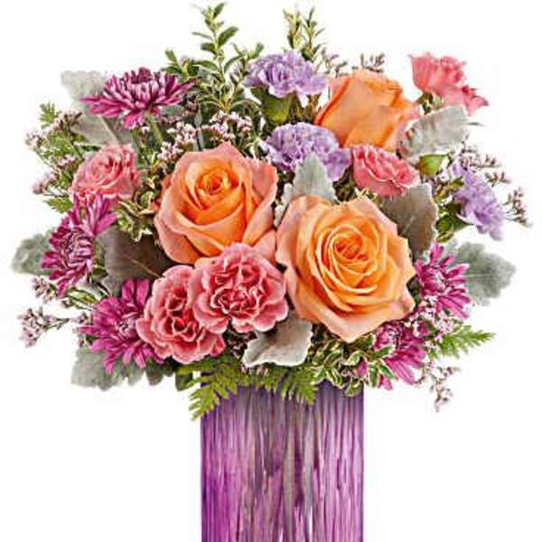 Bouquet of peach and pink roses in a purple glass vase