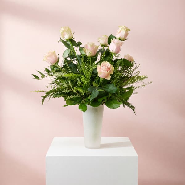Pink roses arranged in a white vase