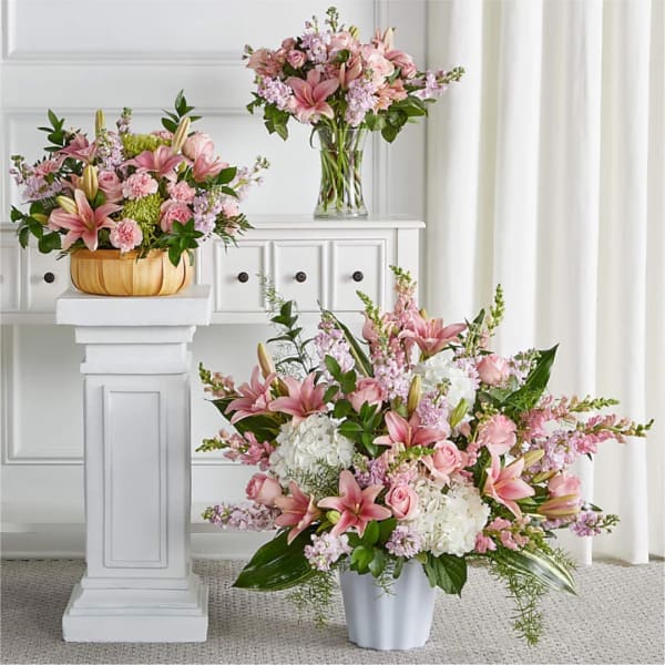 Pink lily and rose arrangements in white and gold containers