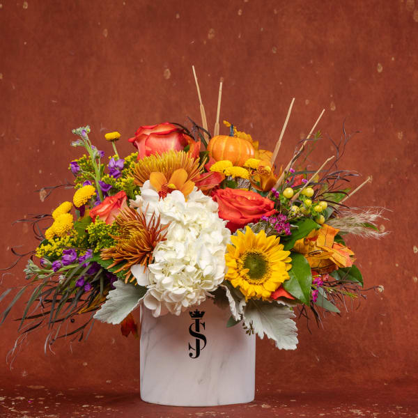 Mixed autumn bouquet in a white vase with sunflowers, roses, and hydrangea