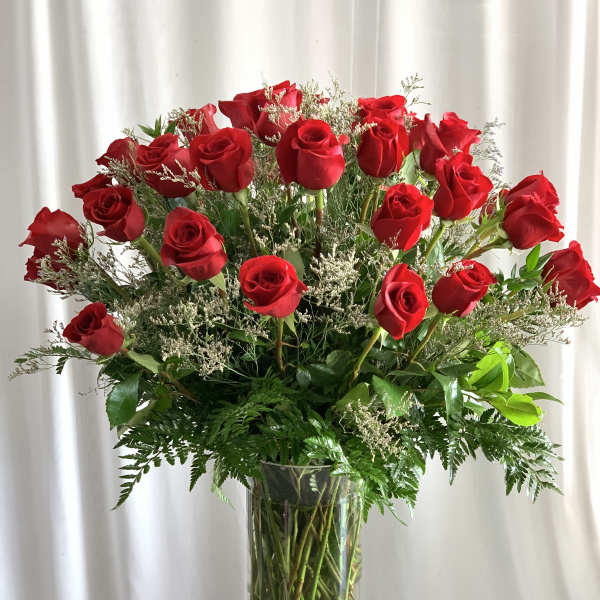 Red roses arranged in a clear glass vase