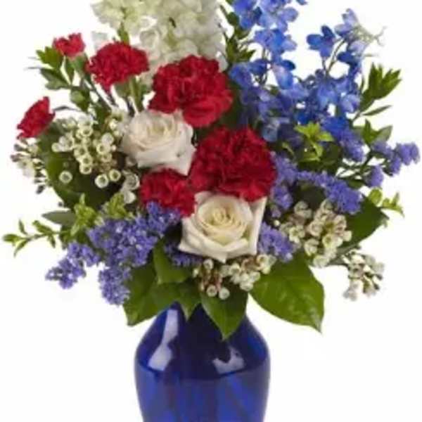 Mixed red, white, and blue flowers in a cobalt vase