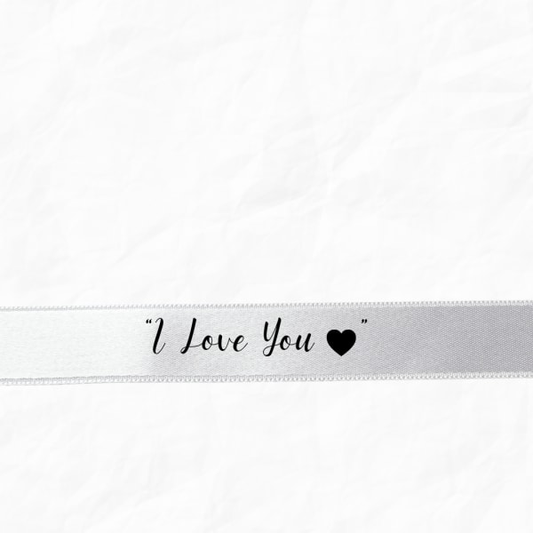 White ribbon with the words "I Love You" and a heart
