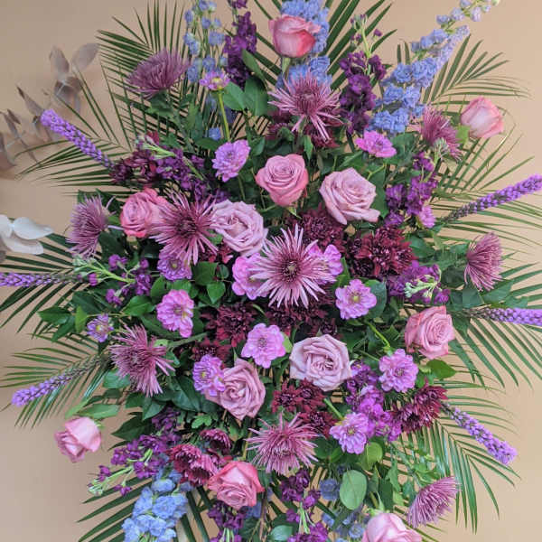 Large standing floral spray with pink roses and purple blooms
