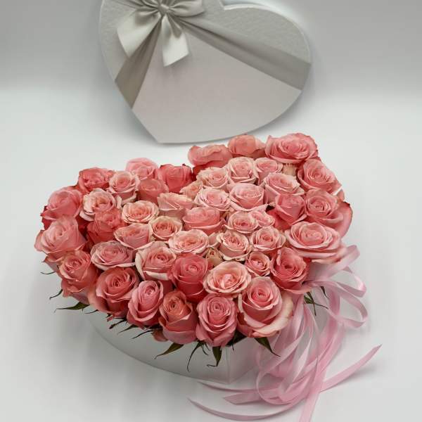 Heart-shaped box of pink roses with a ribbon bow