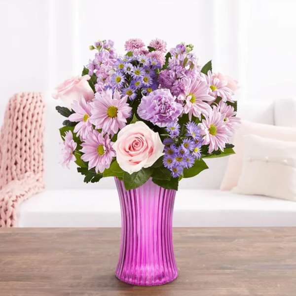 Pink and lavender mixed bouquet in a tall purple vase