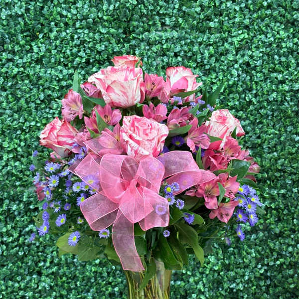 Pink and purple mixed bouquet in a glass vase with a pink bow