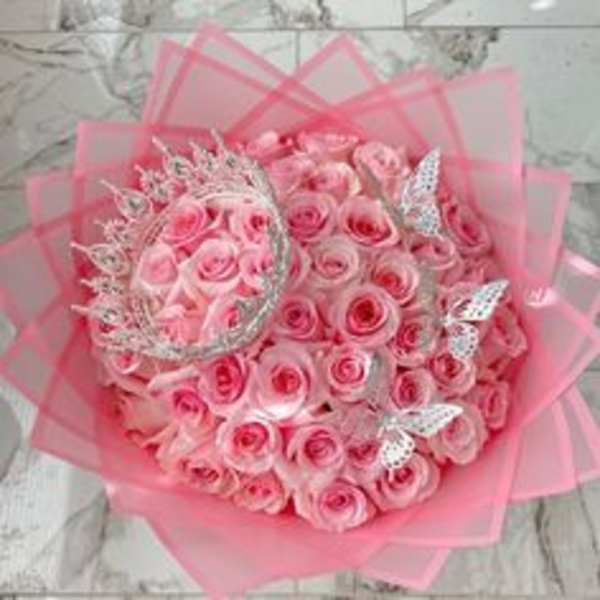 Bouquet of pink roses wrapped in pink paper with silver butterfly accents