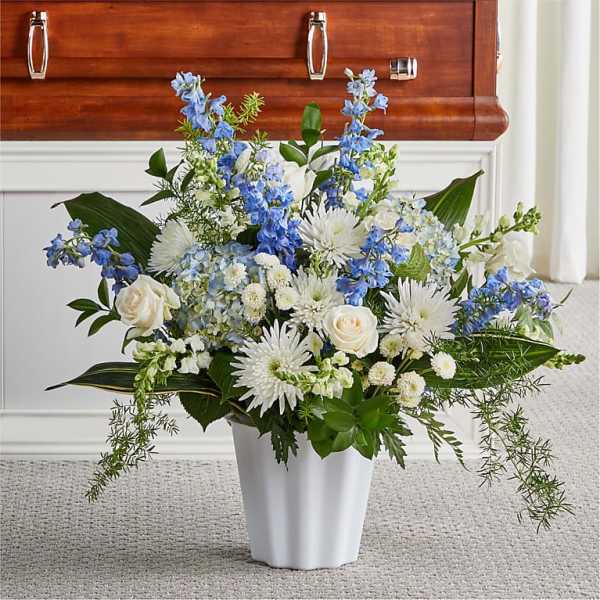 White and blue floral arrangement in a white vase