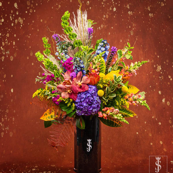 Colorful mixed flower arrangement in a tall black vase