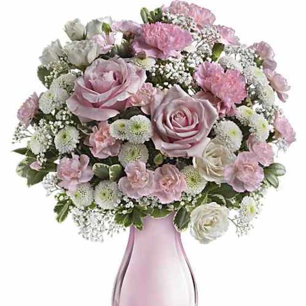 Pink and white rose bouquet in a pink glass vase