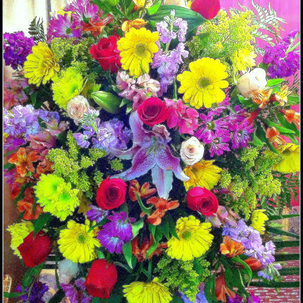 Large mixed bouquet with roses, lilies, and bright daisy-like flowers