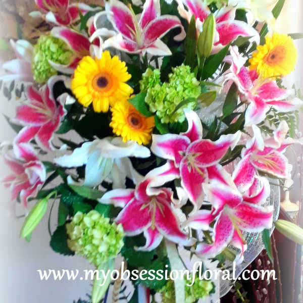 Bouquet of pink lilies, yellow gerbera daisies, and green hydrangeas