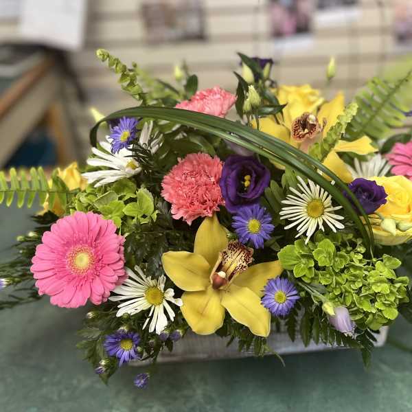 Mixed bouquet with pink gerberas, yellow lilies, and purple daisies