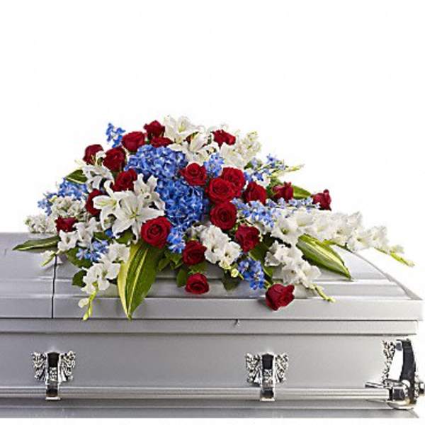Red, white, and blue floral spray on a silver casket