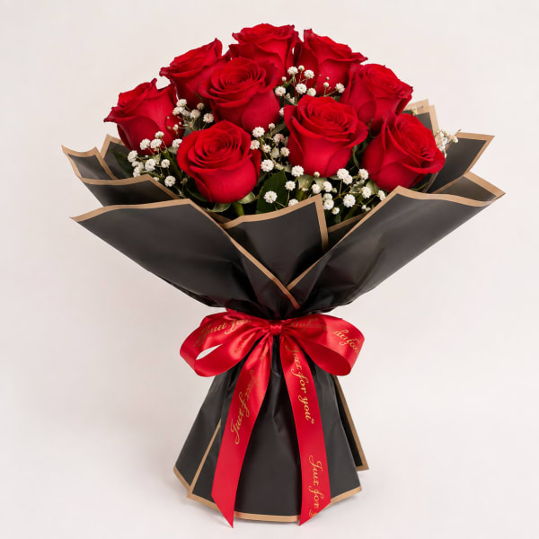Bouquet of red roses with baby's breath wrapped in black paper and a red ribbon