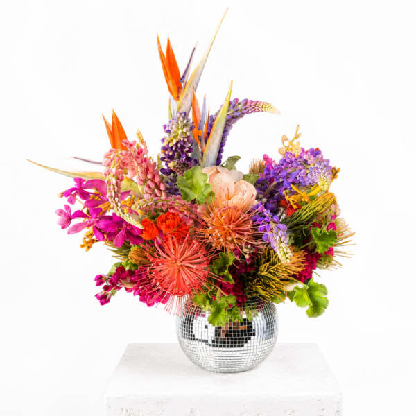 Colorful tropical bouquet in a mirrored round vase