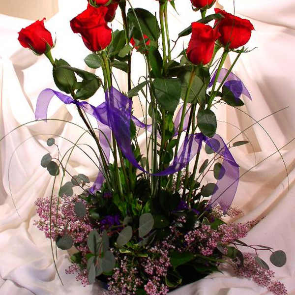 Tall bouquet of red roses with purple ribbon and pink filler flowers