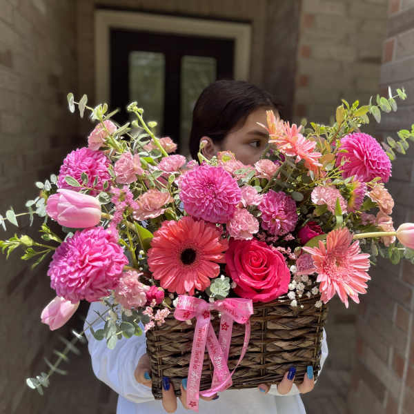 Basket of pink flowers with tulips, roses, and daisies
