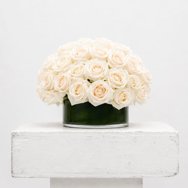 White roses arranged in a low glass vase