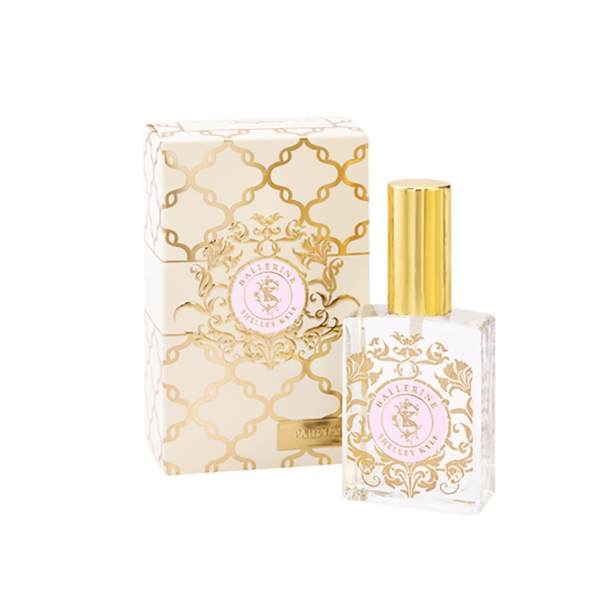 Perfume bottle with gold cap beside a matching patterned box