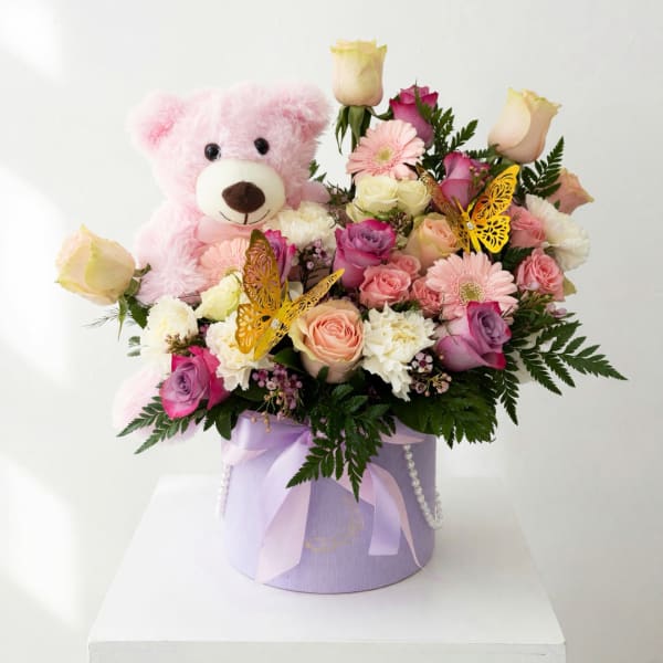 Pink teddy bear with a pastel rose bouquet in a lavender hatbox