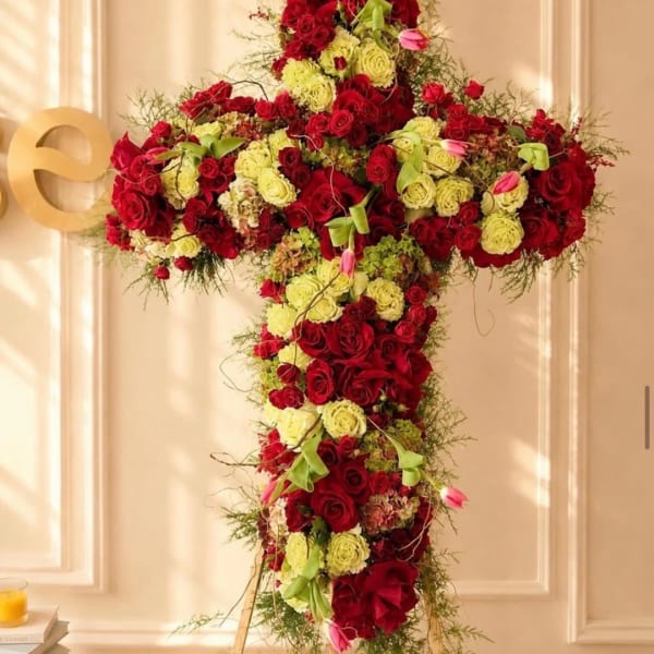 Large cross-shaped floral arrangement of red and pale yellow roses