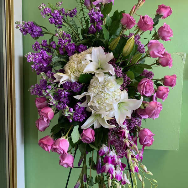 Standing floral spray with pink roses, white lilies, and purple blooms