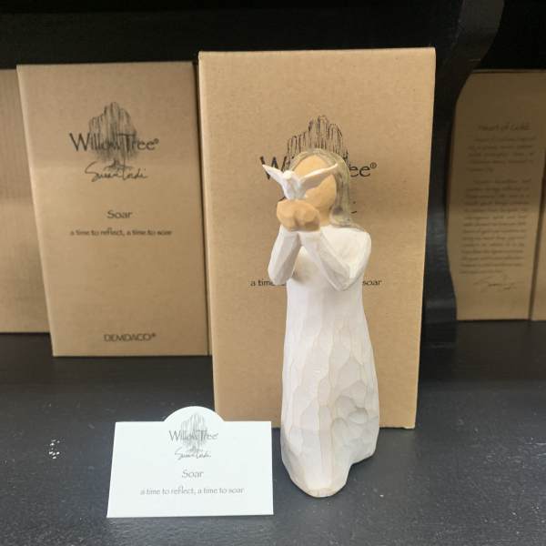 White angel figurine in front of cardboard gift boxes