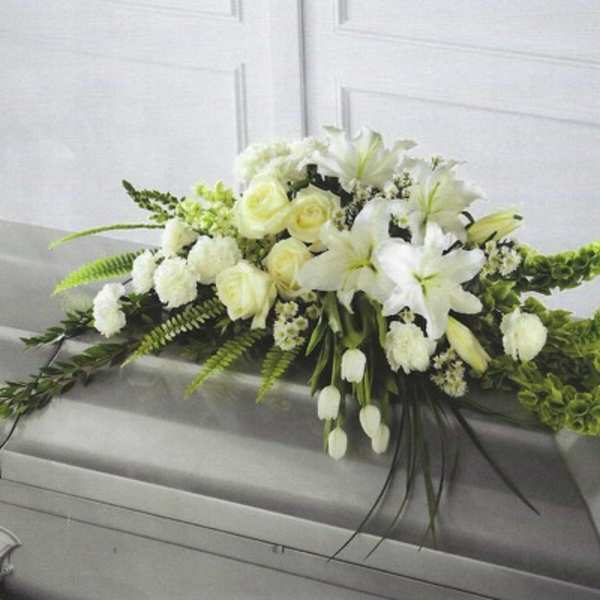 White floral casket spray with lilies and roses