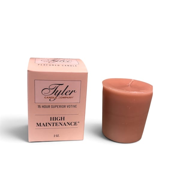 Pink boxed votive candle beside a brown candle