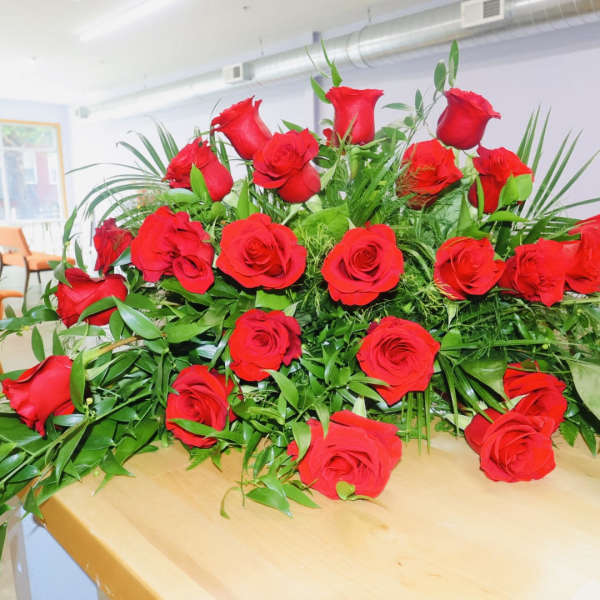 Large arrangement of red roses with greenery on a table