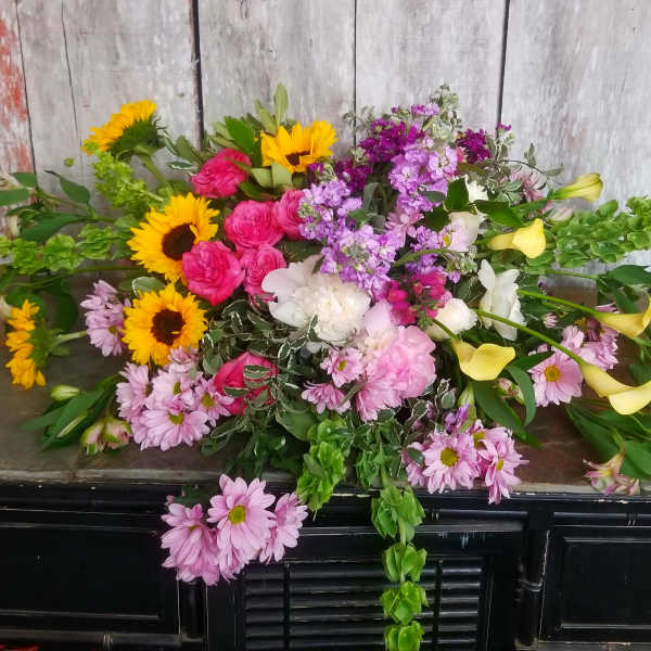 Mixed bouquet with sunflowers, pink roses, lilies, and purple flowers