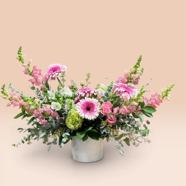 Pink and white mixed flower arrangement in a white vase