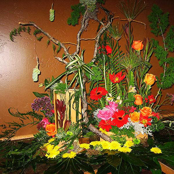 Large tropical floral arrangement with bright mixed blooms and branches