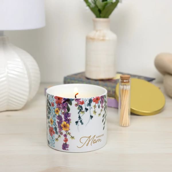 Floral-scented candle in a white jar with "Love you Mom" text